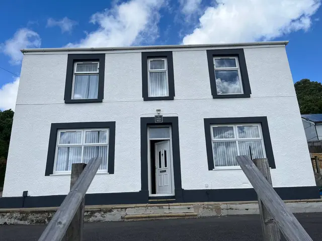 A Swansea farmhouse front elevation in brilliant white with charcoal window surrounds.