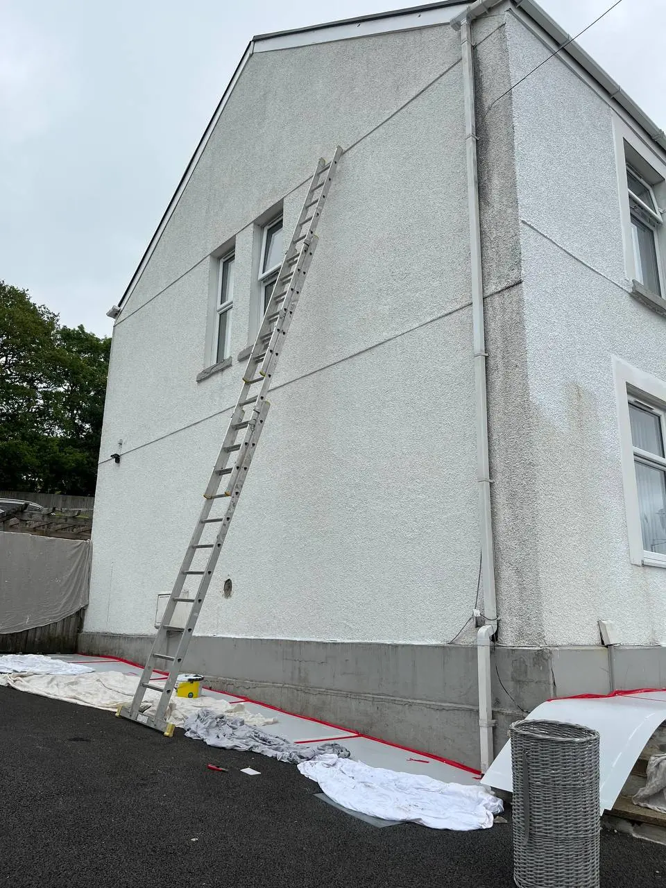 Before: a tall gable end in Swansea, stained and streaked, with a ladder against the wall.