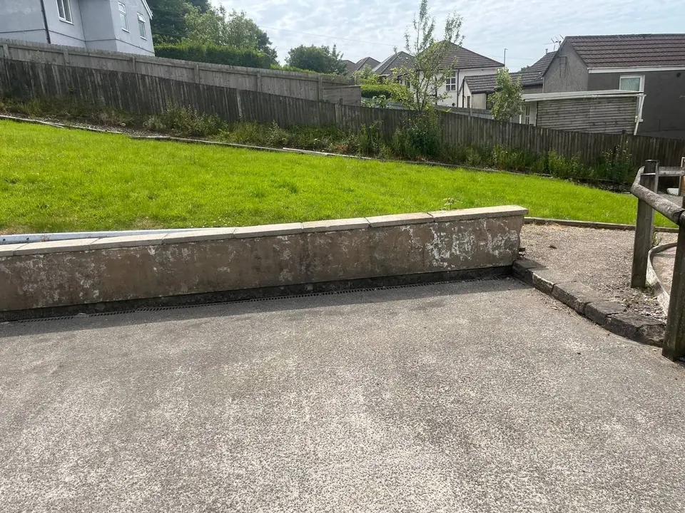 Before: a stained and mossy garden retaining wall at a Swansea property.